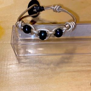 Leather and pearl bracelet. The leather is silver and potato pearls are blue-ish